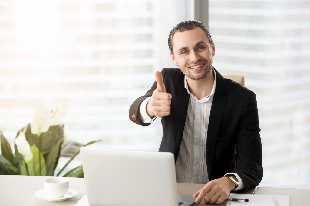 businessman doing thumbs up while working