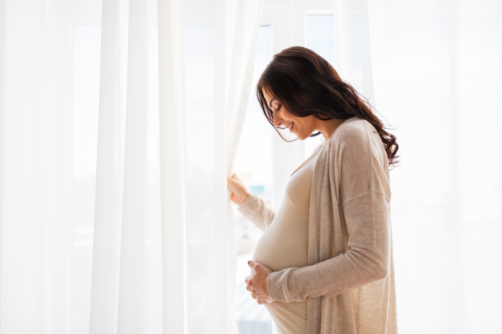 pregnant woman infront of drapes