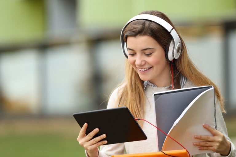 woman holding gadget and notebook