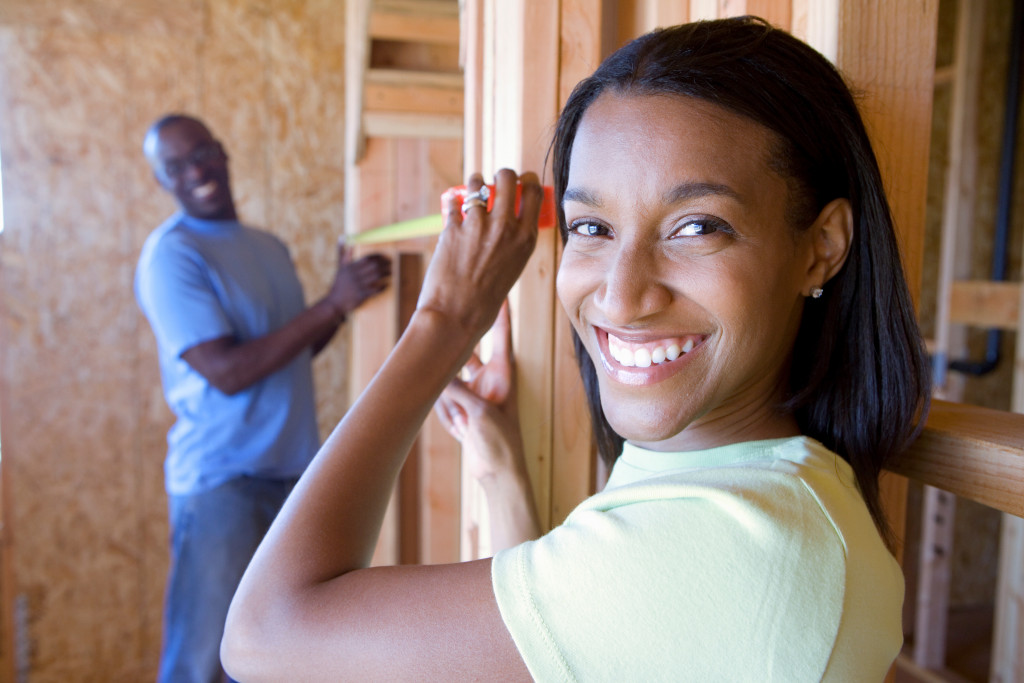 two people smiling while building a home
